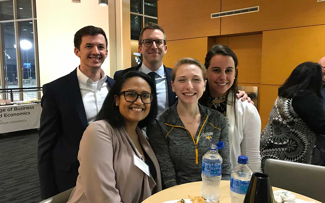 young alums smiling at the basketball game