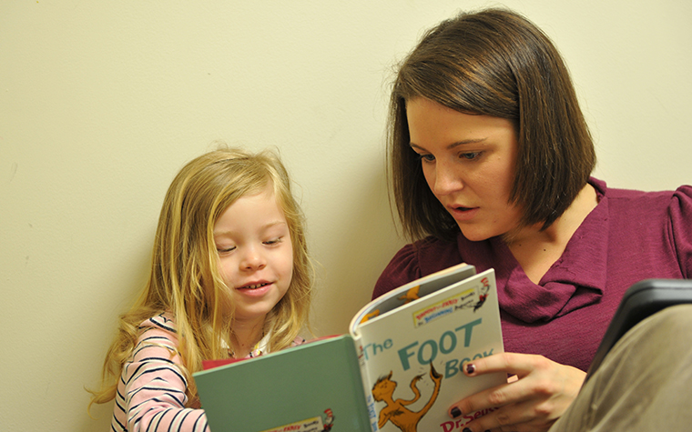 TU student helping young child learn to read