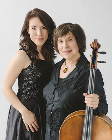 Cecylia Barczyk and her daughter Elizabeth Borowsky, both in formal black clothes, smile at the camera, Cecylia holding her cello