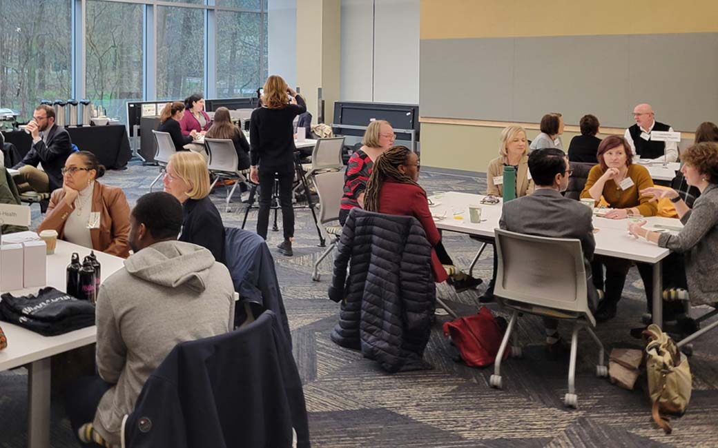 groups of tu faculty and staff working around tables with community partners