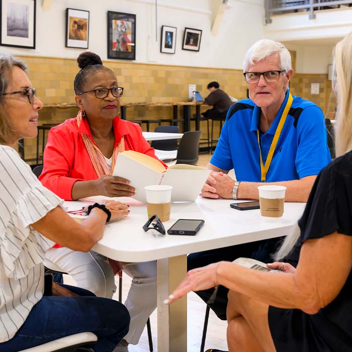 group of Osher members sitting around a table discussing book
