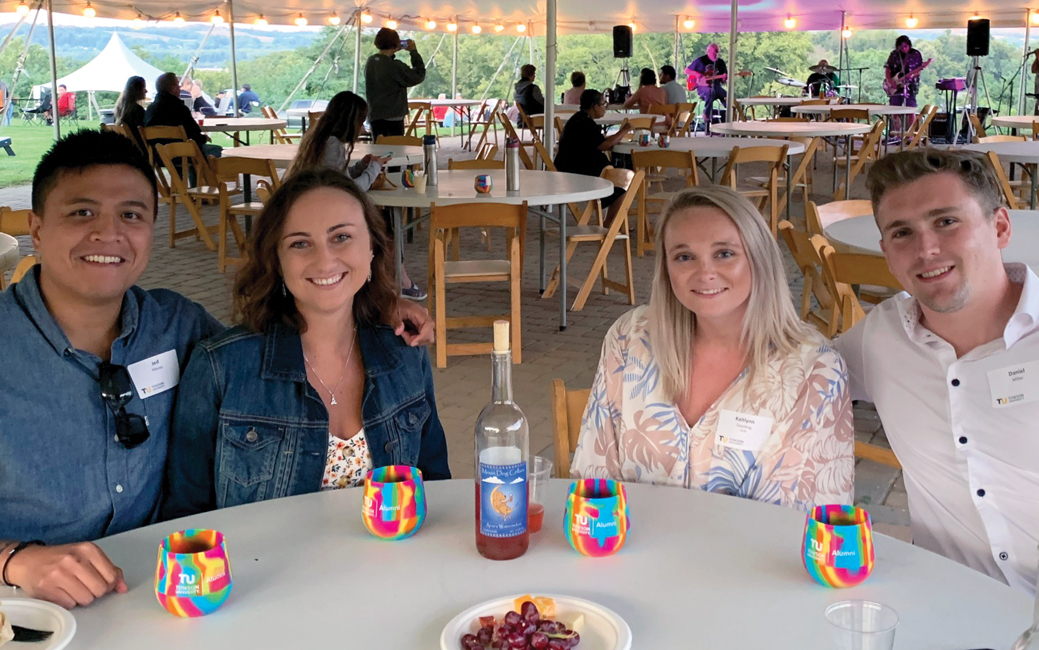 A group of people sitting outside at a winery