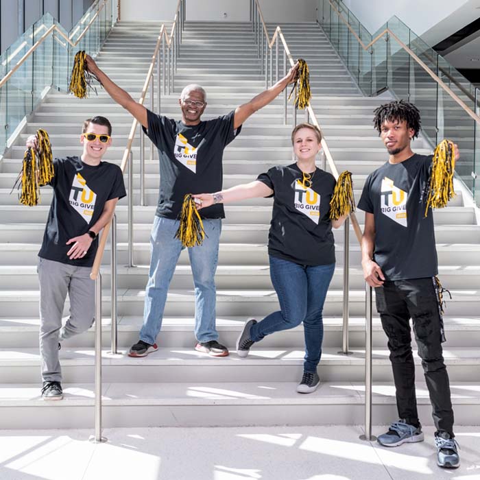 Four students holding pom poms