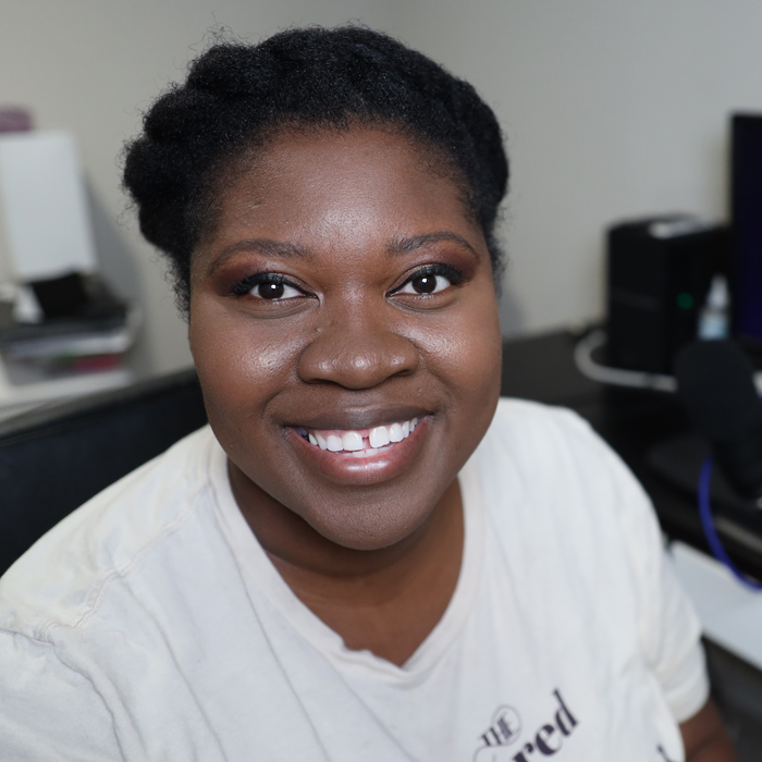 Headshot of Aseloka Smith in front of a computer
