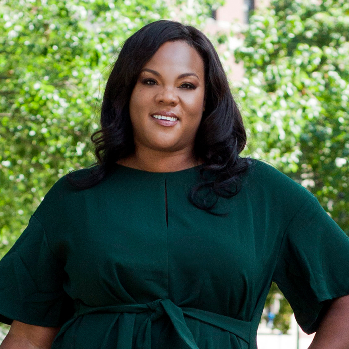 smiling Black woman in front of trees