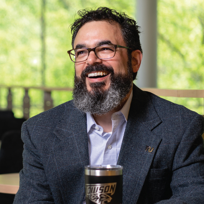 Anthony Skevakis sitting with a cup of coffee