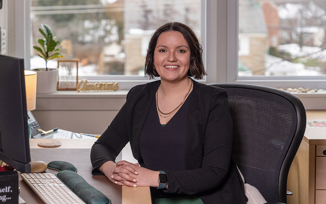 woman sits at desk in Institute for Well-being