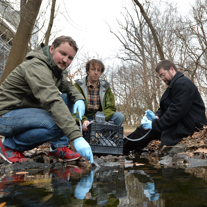 Professor and students taking water samples