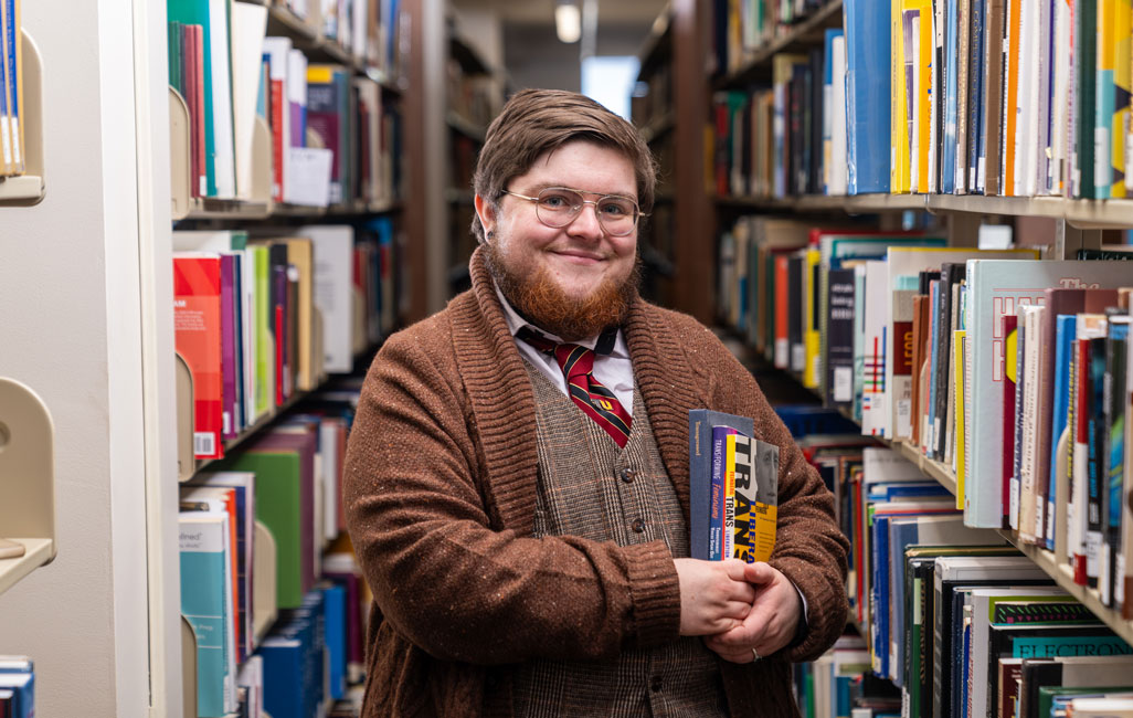Student holds books in library