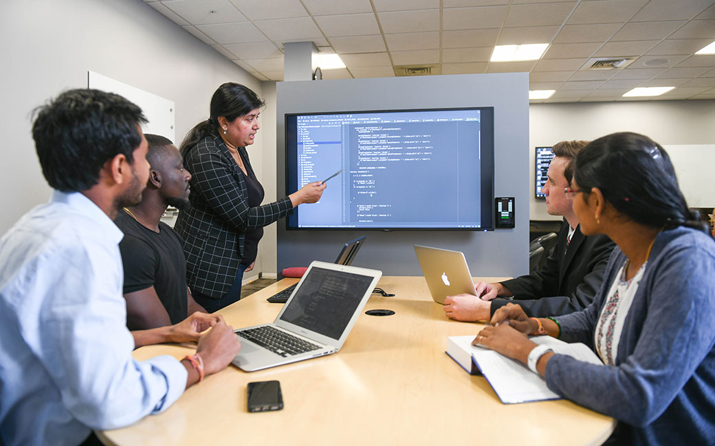 Teaching at Cyber4All center Students looking at screen with teacher instructing