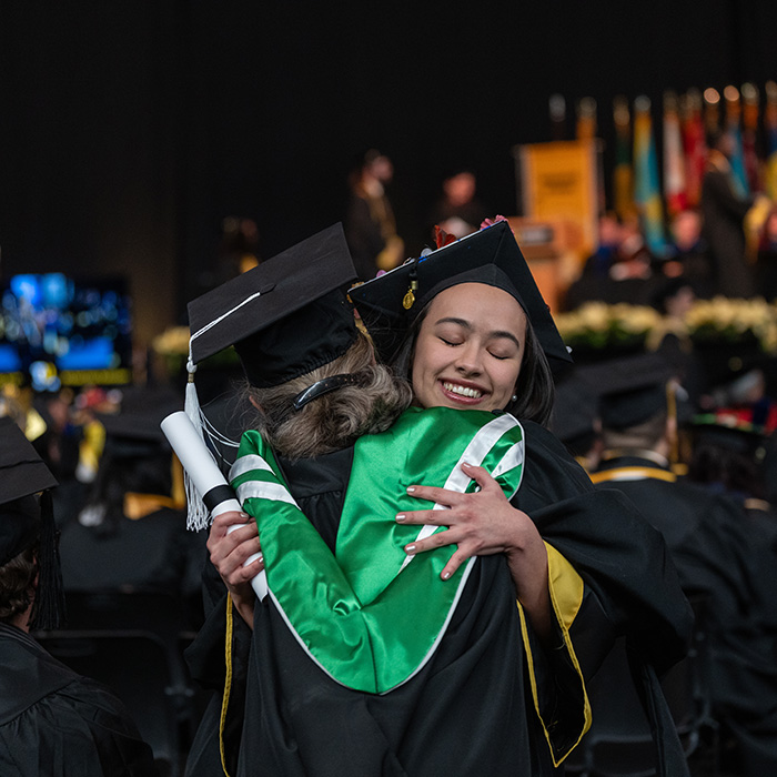 TU graduate hugging TU staff member
