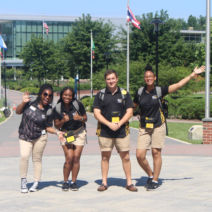 four orientation leader smiling on campus