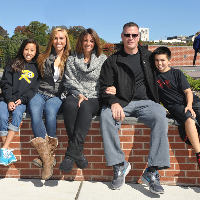 family sitting on top of a TU wall