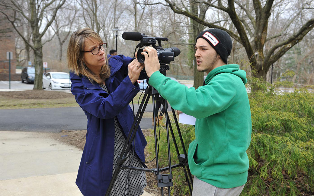 professor and student adjusting digital video camera