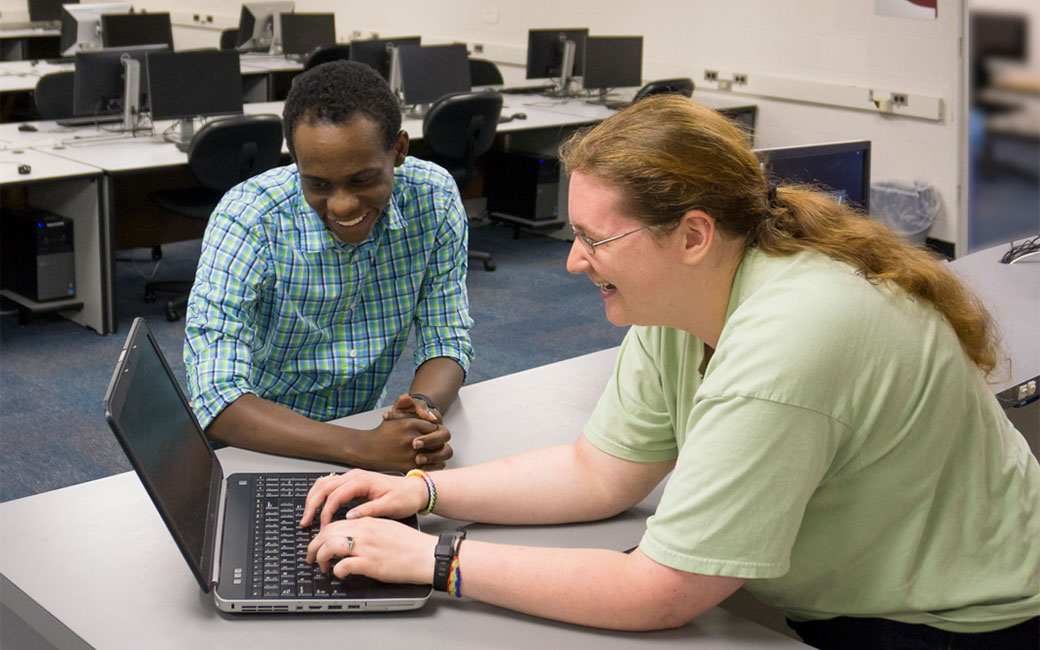 Technology Support Desk staff help a student troubleshoot a laptop problem